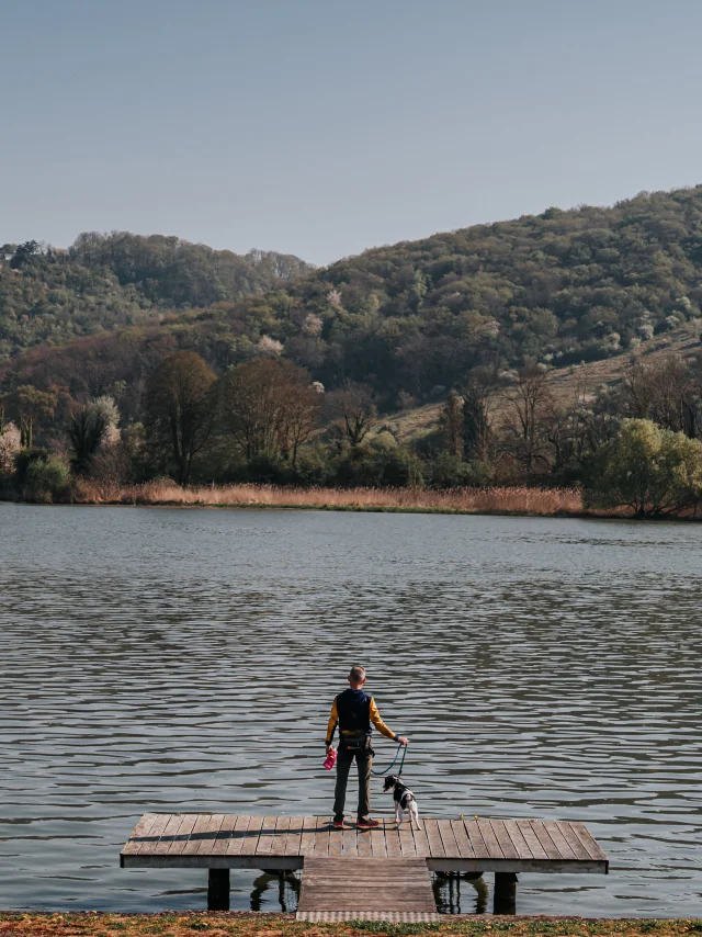 Touriste avec son chien sur un ponton face à la Seine à Poses